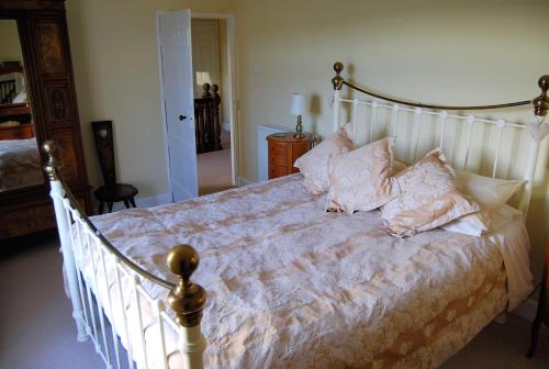 Un dormitorio con una cama grande con almohadas. en Pott Hall en Masham