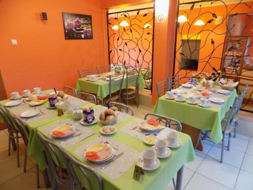 a group of tables with green table cloths on them at Malinka in Rewal