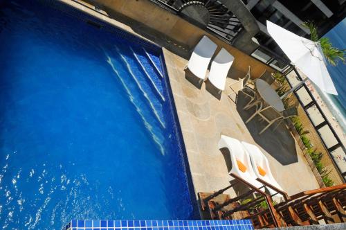 a swimming pool with chairs next to a swimming pool at Oceano Copacabana Hotel in Rio de Janeiro
