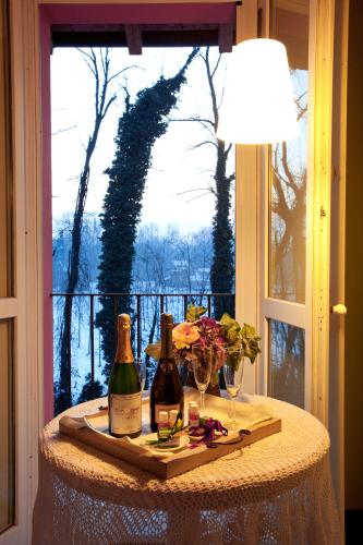 a table with two bottles and glasses and a window at Agriturismo Cascina Caremma in Besate