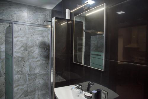 a bathroom with a sink and a shower with a mirror at Adele in Mizhhirʼʼya