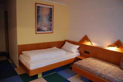 a small room with two beds and a picture on the wall at Hotel Johnel in Hennef