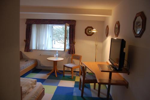 a living room with a tv and a table with a table at Hotel Johnel in Hennef