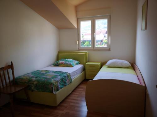 ein kleines Zimmer mit 2 Betten und einem Fenster in der Unterkunft Apartment Lena in Kaštela