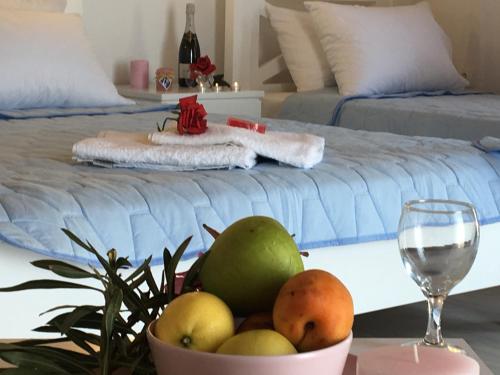 eine Schale Obst auf einem Tisch neben einem Bett in der Unterkunft Samothraki Suites Kalisti in Xiropótamos