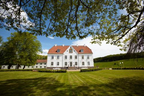 a large white house with a red roof at Haraldskær Sinatur Hotel & Konference in Vejle