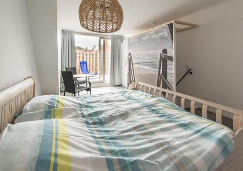 Un dormitorio con una cama grande y una ventana. en Holiday Home Zuidstraat 30B, en Westkapelle