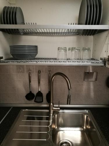 a sink in a kitchen with utensils on a shelf at C'era una "volta"... un appartamento a Torino in Turin