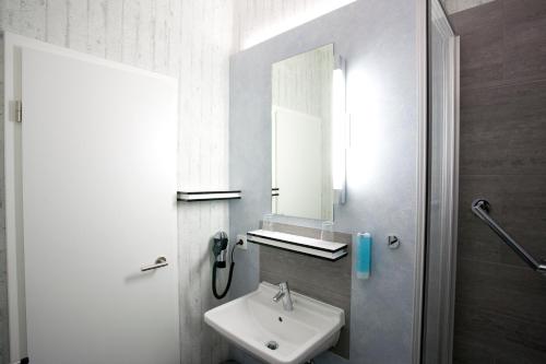 a bathroom with a sink and a mirror at Hotel Cristall - Frankfurt City in Frankfurt/Main