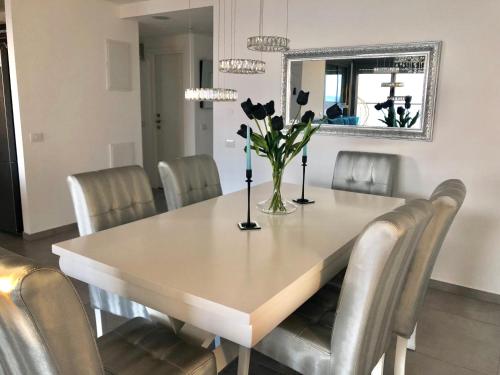 a dining room table with chairs and a vase of flowers at Panorama Apartment " City Garden " in Bat Yam
