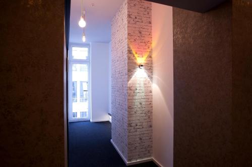 a hallway with a brick wall with a light on it at Hotel Cristall - Frankfurt City in Frankfurt/Main