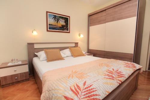 a bedroom with a large bed with a wooden headboard at Apartment Carmen in Trogir