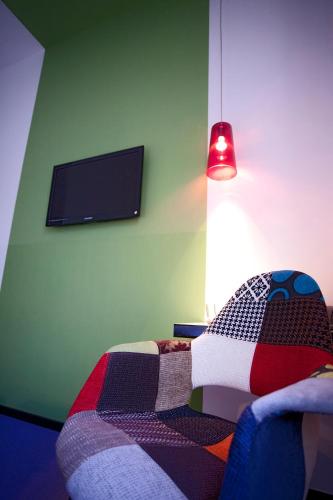 a bedroom with a colorful bed with a tv on the wall at Hotel Cristall - Frankfurt City in Frankfurt/Main
