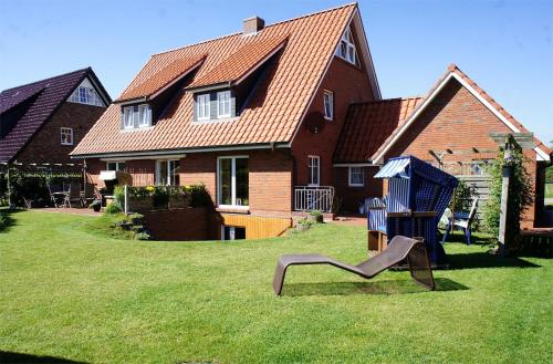 a playground in a yard in front of a house at Haus Wyden in Utersum