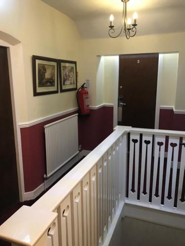 a hallway with a staircase with a fire extinguisher at Barons Court Hotel in Wolverhampton