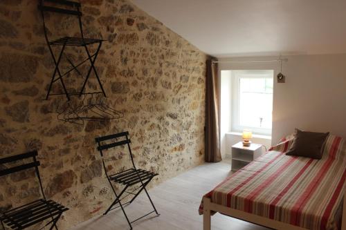 a bedroom with a bed and two chairs at A chacun son nid in Les Épesses