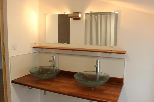 two bowls on a wooden counter with a mirror at A chacun son nid in Les Épesses