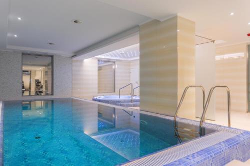 una gran piscina con 2 lavabos y una bañera en Outlet Hotel Polgár, en Polgár