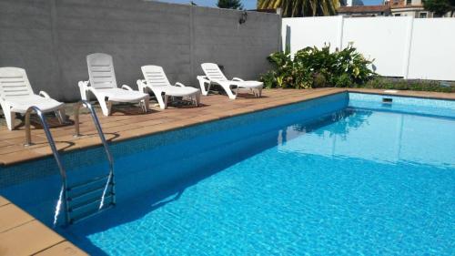a group of chairs sitting next to a swimming pool at Casa Balbina in O Grove