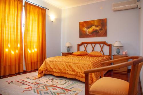 a bedroom with a bed with an orange bedspread at Quinta Vila Verde in Cinfães