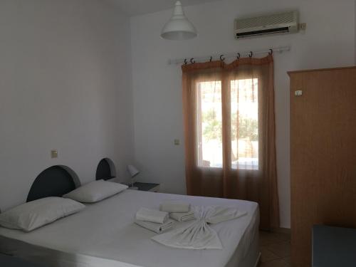 una camera da letto con un grande letto bianco e una finestra di Camares a Chora Folegandros