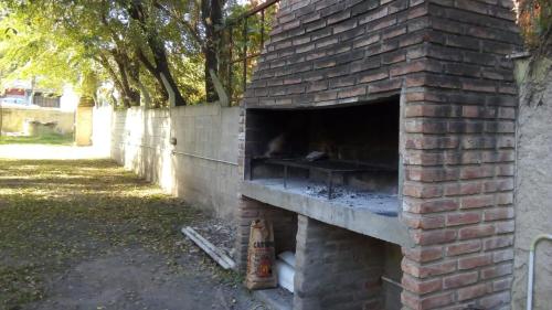 een bakstenen pizzaoven in de buitenlucht in een tuin bij Hotel Nuevo Fatica in Villa Carlos Paz