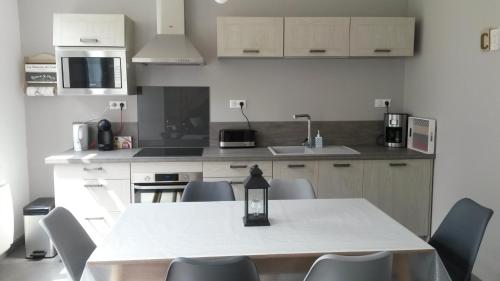 une cuisine avec une table et des chaises dans une cuisine dans l'établissement COTTAGE DE L'ANCRE, à Albert