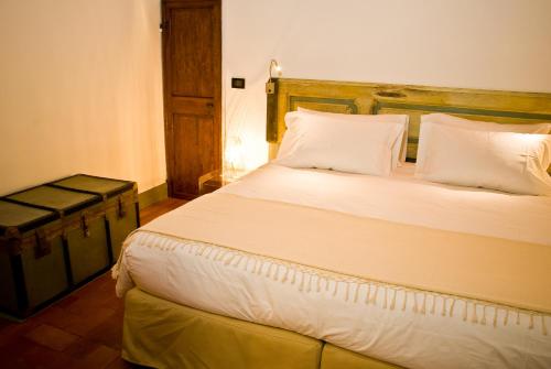 a bedroom with a bed with white sheets and pillows at Callegherie 21 Boutique B&B in Imola