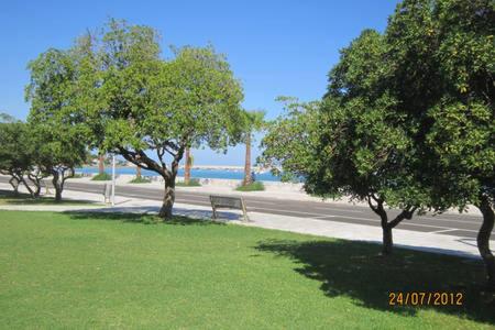 a park with trees and a bench in the grass at Ambra di mare in SantʼAgata di Militello