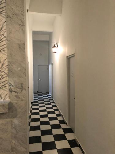 a hallway with a black and white checkered floor at Navona Studios in San Juan