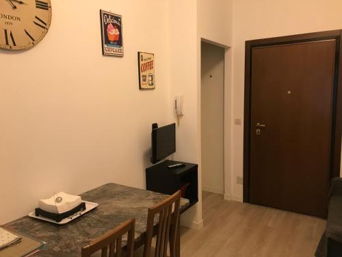 a dining room with a table and a clock on the wall at Portello in Padova