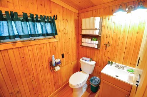a wooden bathroom with a toilet and a sink at Glacier Homestead in Coram