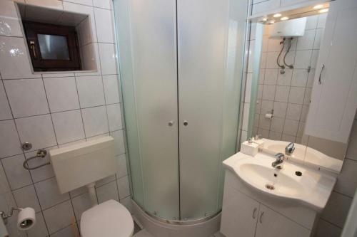 a bathroom with a shower and a toilet and a sink at Kuća za odmor Perić in Seline
