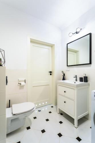 a bathroom with a toilet sink and a mirror at Apartament 43 z widokiem na jezioro - Giżycko in Giżycko