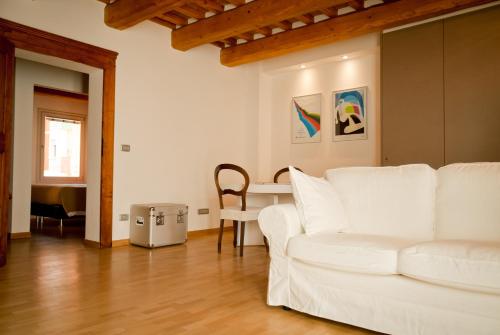 a living room with a white couch and a table at Callegherie 21 Boutique B&B in Imola