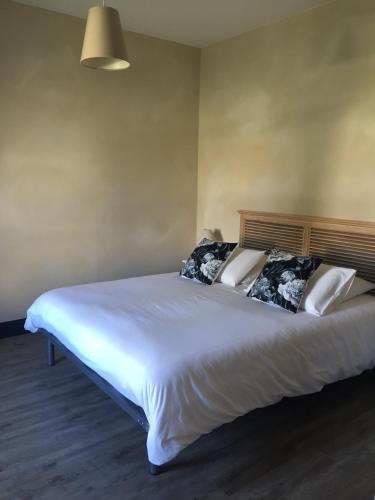Elle comprend un grand lit avec des draps et des oreillers blancs. dans l'établissement La Rochelle L'ile de Ré Autrement, à Nieul-sur-Mer