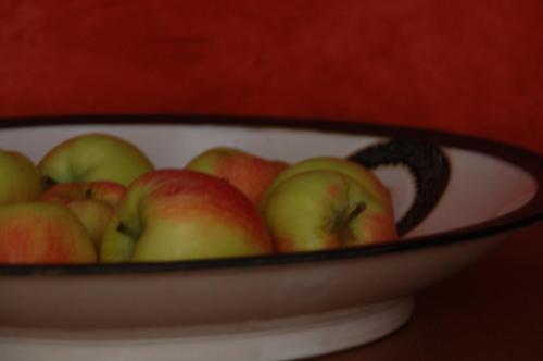 un tazón de manzanas rojas y verdes sobre una mesa en Kunsthaus en Quedlinburg
