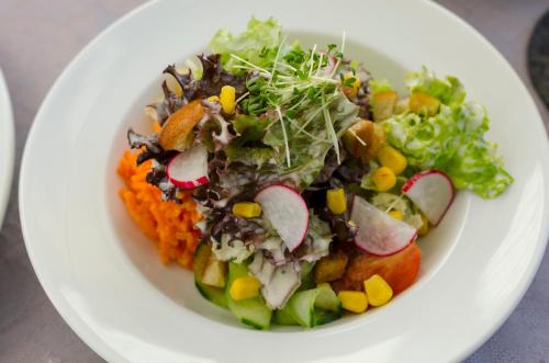 a white plate of food with a salad on it at Gasthof Ziegler Hotel & Restaurant in Lindau