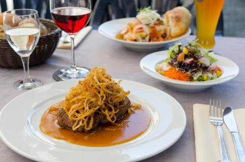 a table with plates of food and glasses of wine at Gasthof Ziegler Hotel & Restaurant in Lindau