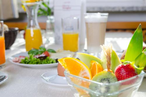 a table topped with a bowl of fruit and drinks at Gasthof Ziegler Hotel & Restaurant in Lindau