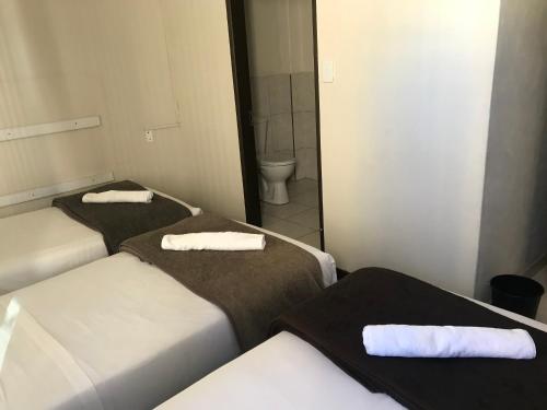 2 letti in una piccola camera con servizi igienici di Businessburg Hotel a Johannesburg