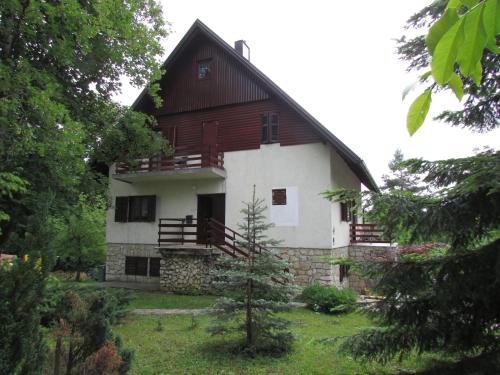 
a large white house with a large window at Guest House Nenad in Plitvička Jezera
