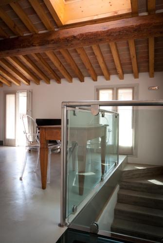 a glass elevator in a room with a table and stairs at Callegherie 21 Boutique B&B in Imola