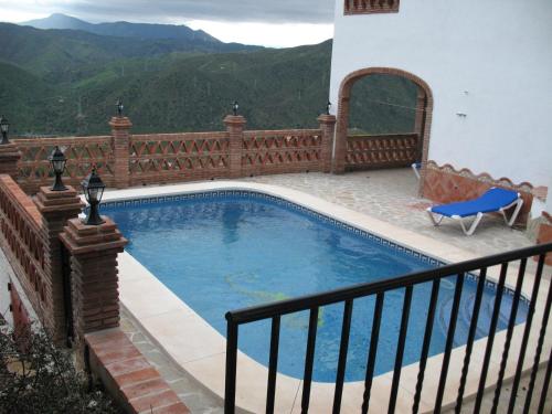 a swimming pool on a balcony with a fence at Casa Encina - Encinasola Turismo Rural. in Alora