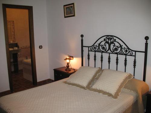 a bedroom with a bed and a lamp on a table at Casa Encina - Encinasola Turismo Rural. in Alora