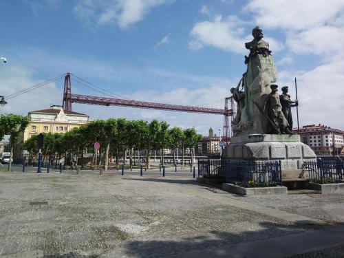 a statue in front of a bridge with a crane at Apartamento La Villa EBi 867 in Portugalete