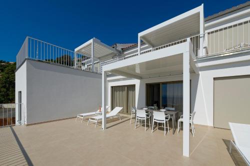 a balcony of a house with a table and chairs at Zlatni Zalaz,Apartments,Supetarska Draga in Supetarska Draga