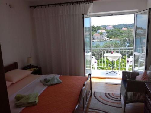 Schlafzimmer mit einem Bett und Blick auf einen Balkon in der Unterkunft Adrian's Apartments & Winery in Lumbarda