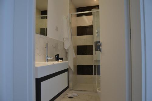 a bathroom with a sink and a shower at Centurio luxury rooms in Tropea