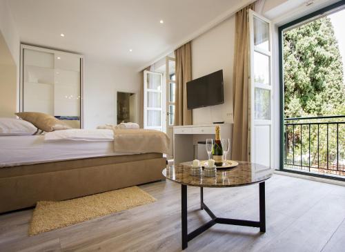 - une chambre avec un lit et une table avec une télévision dans l'établissement Well Of Life Luxury Rooms, à Split